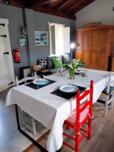 a table with a white table cloth and two red chairs at Errekaondo in Areatza