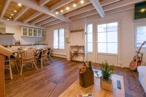 un salon avec une cuisine et une table avec une guitare dans l'établissement Les Maisons de Maje - La Home45, à Honfleur