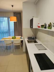 a kitchen with a sink and a table with chairs at Avo Apartments in Olimp +15 photos