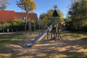 a playground with a slide in a park at Kur-Pur eine Ferienwohnung mit Sauna und Garten in Husum
