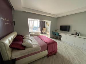a bedroom with a large bed and a television at Residence Sky in Sochi