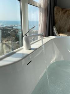 a bath tub with water pouring from a faucet at Residence Sky in Sochi