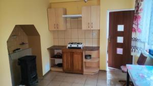 a kitchen with wooden cabinets and a stove in it at Agroturystyka U Jadwigi Lipsk in Lipsk +6 photos