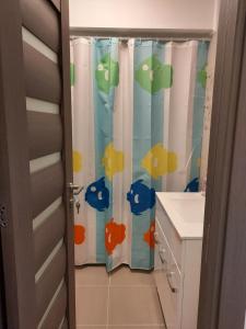 a bathroom with a shower curtain with fish on it at BYA Luxury in Valea Lupului