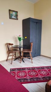 une salle à manger avec une table, deux chaises et un tapis dans l'établissement Agroturystyka U Jadwigi, à Lipsk