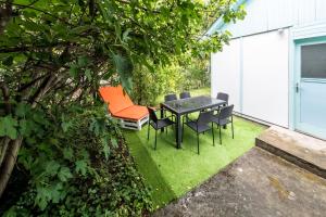 a patio with a table and chairs on the grass at Penge Bungalók in Balatonalmádi