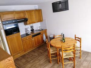 a kitchen with a wooden table and a table and chairs at Julie's Home in Bray-Dunes