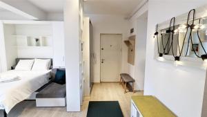 ピテシュティにあるANR Studioのベッド1台と廊下が備わる小さなアパートメントです。