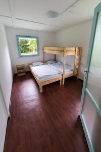 a bedroom with two bunk beds and a window at Penge Bungalók in Balatonalmádi