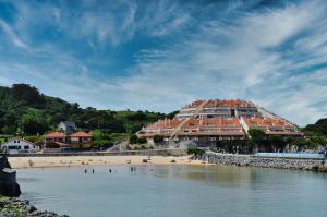 a building on a beach with people on the beach at Miramar - 5710 in Quejo