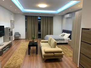 um quarto com uma cama, um sofá e uma mesa em Hotel Vasho em Gjirokastër