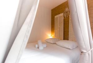 białe łóżko z 2 poduszkami i oknem w obiekcie Au Bourg Neuf w Orleanie