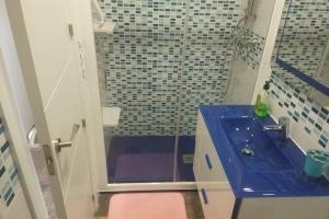 a bathroom with a blue sink and a shower at Casa Juanma in Córdoba