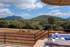 eine Terrasse mit Blick auf ein Feld und die Berge in der Unterkunft Son Vorera, situada en una colina, con piscina. in Es Carritxo