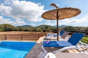 eine Terrasse mit Stühlen, einem Sonnenschirm und einem Pool in der Unterkunft Son Vorera, situada en una colina, con piscina. in Es Carritxo