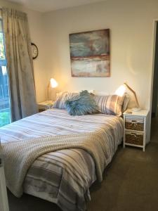 a bedroom with a bed with a blue pillow on it at Bed & Breakfast in the Heart of Fendalton in Christchurch