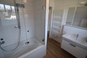 a white bathroom with a shower and a sink at Dat Smucke Huus - 6 Personen strandnah unter Reet in Boltenhagen - 3 SZ - Finnische Sauna - 2 Strandkörbe - Strand 650m in Boltenhagen +14 photos