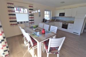 a kitchen and dining room with a wooden table and chairs at Dat Smucke Huus - 6 Personen strandnah unter Reet in Boltenhagen - 3 SZ - Finnische Sauna - 2 Strandkörbe - Strand 650m in Boltenhagen