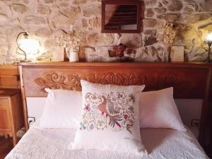 1 cama con cabecero de madera y almohada en Casa Lucia, en Mogarraz