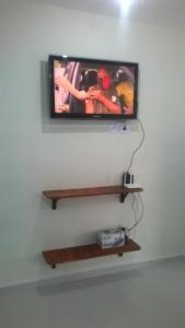 a flat screen tv on a wall with a shelf at Kitnet 1,Vista fantastica in Cabo de Santo Agostinho
