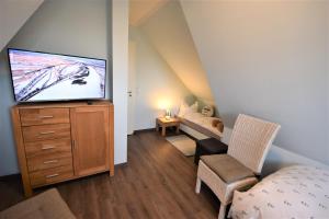 a living room with a tv and a bedroom at Dat Smucke Huus - 6 Personen strandnah unter Reet in Boltenhagen - 3 SZ - Finnische Sauna - 2 Strandkörbe - Strand 650m in Boltenhagen