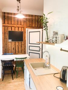 a kitchen with a sink and a table with chairs at Spacious Supeluse Apartment in Pärnu