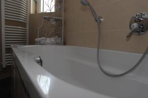 Das Bad ist mit einer Badewanne mit einer Dusche ausgestattet. in der Unterkunft Apartment aPriori-Baden-Baden in Baden-Baden
