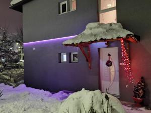 una casa con una puerta cubierta de nieve con un adorno navideño en Nikolaj Lux, en Nova Varoš