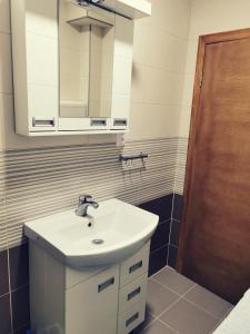 uma casa de banho com um lavatório e um espelho em Nikolaj Lux em Nova Varos