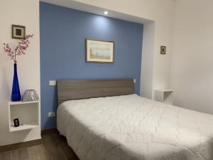 una camera con un letto con una parete blu di Dimora dei Falisci a Montefiascone