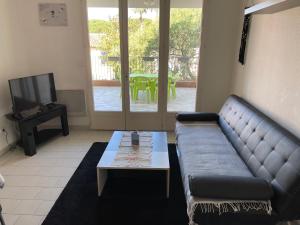 sala de estar con sofá y mesa de centro en Apartment Port Cogolin with garden view, en Grimaud