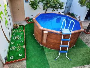 a wooden bath tub with a ladder and a chair in it at Casa do Neto Tiago in Fundão