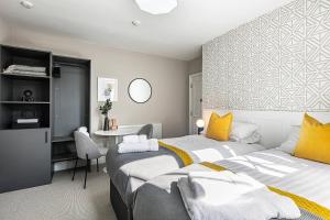 a bedroom with two beds and a table in it at The Belmont - Harrogate Stays in Harrogate