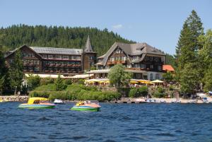 two boats in the water in front of a resort at Treschers Schwarzwald Hotel in Titisee-Neustadt