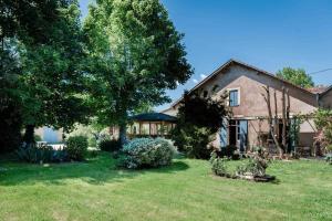 a house with a yard with grass and trees at Les bergeronnettes - Chambres d'Hôtes Bergerac in Bergerac