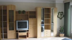 - un salon avec une télévision et des étagères en bois dans l'établissement Haus Falkner, à Niederthai