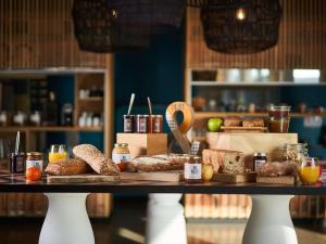 una mesa con diferentes tipos de pan y otros alimentos en Mercure Lyon Genas Eurexpo, en Genas