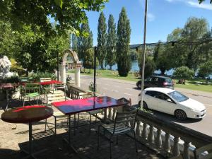 une table, des chaises et une voiture blanche garée dans la rue dans l'établissement Guest house Pizzeria Pazza da Gianni, à Stein am Rhein