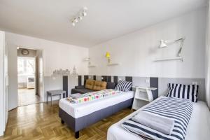 ワルシャワにあるLabo Apartment Metro Plockaのベッドルーム1室(ベッド2台、ソファ付)