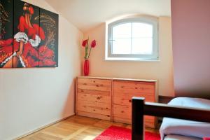 a bedroom with a dresser and a window at Hostel Bailando Wroclawska 25 in Poznań