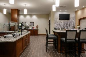 a kitchen with a table and chairs and a television at Staybridge Suites Des Moines Downtown by IHG in Des Moines