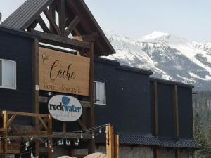 a building with a sign in front of it with a mountain at The Cache Hotel and Lodgings in Golden