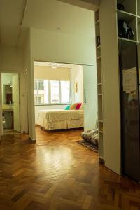 a bedroom with a bed and a hard wood floor at Apê da Cassandra em Copa in Rio de Janeiro