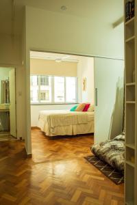 a bedroom with a bed and a large window at Apê da Cassandra em Copa in Rio de Janeiro