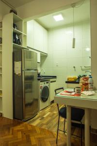 a kitchen with a refrigerator and a table with chairs at Apê da Cassandra em Copa in Rio de Janeiro