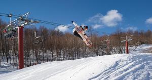 a person jumping in the air on a snowboard at Palcall Tsumagoi Resort Ski & Hotel in Tsumagoi +126 photos