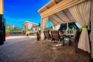 a patio with a table and chairs under a canopy at Villa Barbara in Skradin