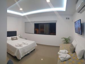 Cette chambre blanche dispose d'un lit et d'un canapé. dans l'établissement Patagonia Apart, à Paraná 7 autres photos