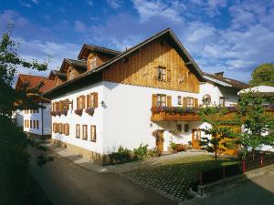 a large white building with a wooden roof at Pension Berg&Bleibe Wertach in Wertach