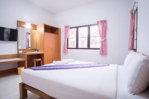 1 dormitorio con 1 cama grande y baño en Ruentara Resort & Villa Buriram en Buriram